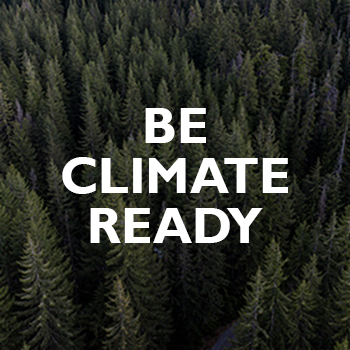 Aerial view of dense evergreen forest with the words BE CLIMATE READY in bold white letters centered over the trees.