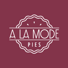 A white outlined scalloped circle with the text A LA MODE above PIES on a maroon background.